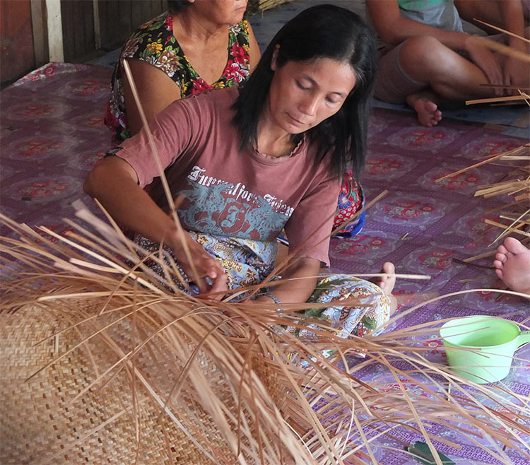 Mujer realizando cestos de paja. Proyecto local en Malasia