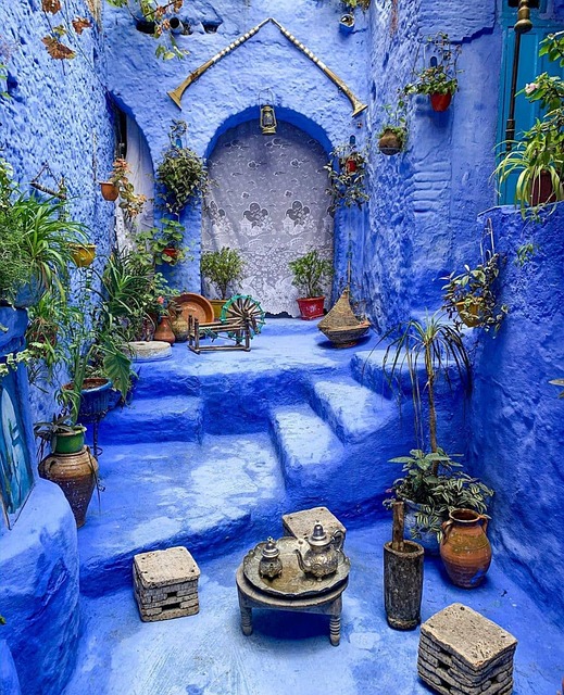 Casa azul de Chefchaouen con plantas, mesa pequeña con tetera y asientos