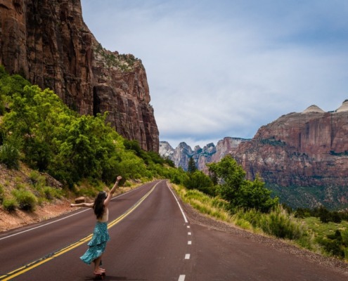 chica disfrutando en una carretera montañosa