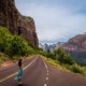 chica disfrutando en una carretera montañosa