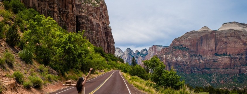 chica disfrutando en una carretera montañosa