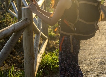 chica con mochila de viajero realizando una fotografía al paisaje