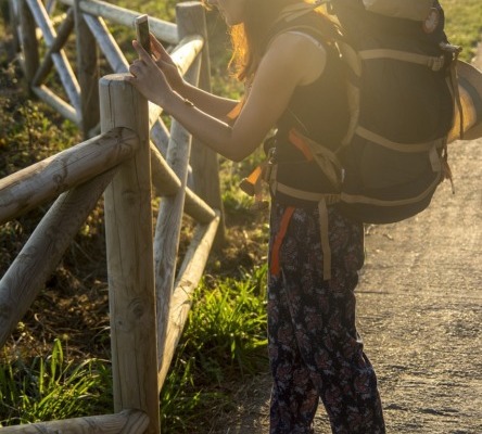 chica con mochila de viajero realizando una fotografía al paisaje